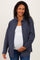 woman wearing a navy checkered maternity shirt over a white tank top and showing her baby bump