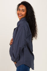 woman wearing a navy blue plaid maternity shirt and holding her baby bump