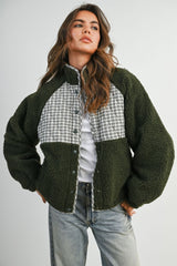 woman wearing a green and gray plaid oversized fleece jacket styled with a white top and denim jeans