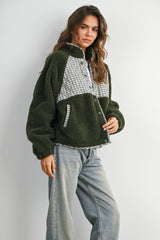 woman wearing an olive green and gray checkered fleece pullover jacket paired with light wash jeans