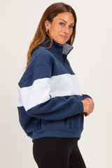 woman wearing a navy blue and light gray half-zip pullover sweatshirt with a relaxed fit and a collar
