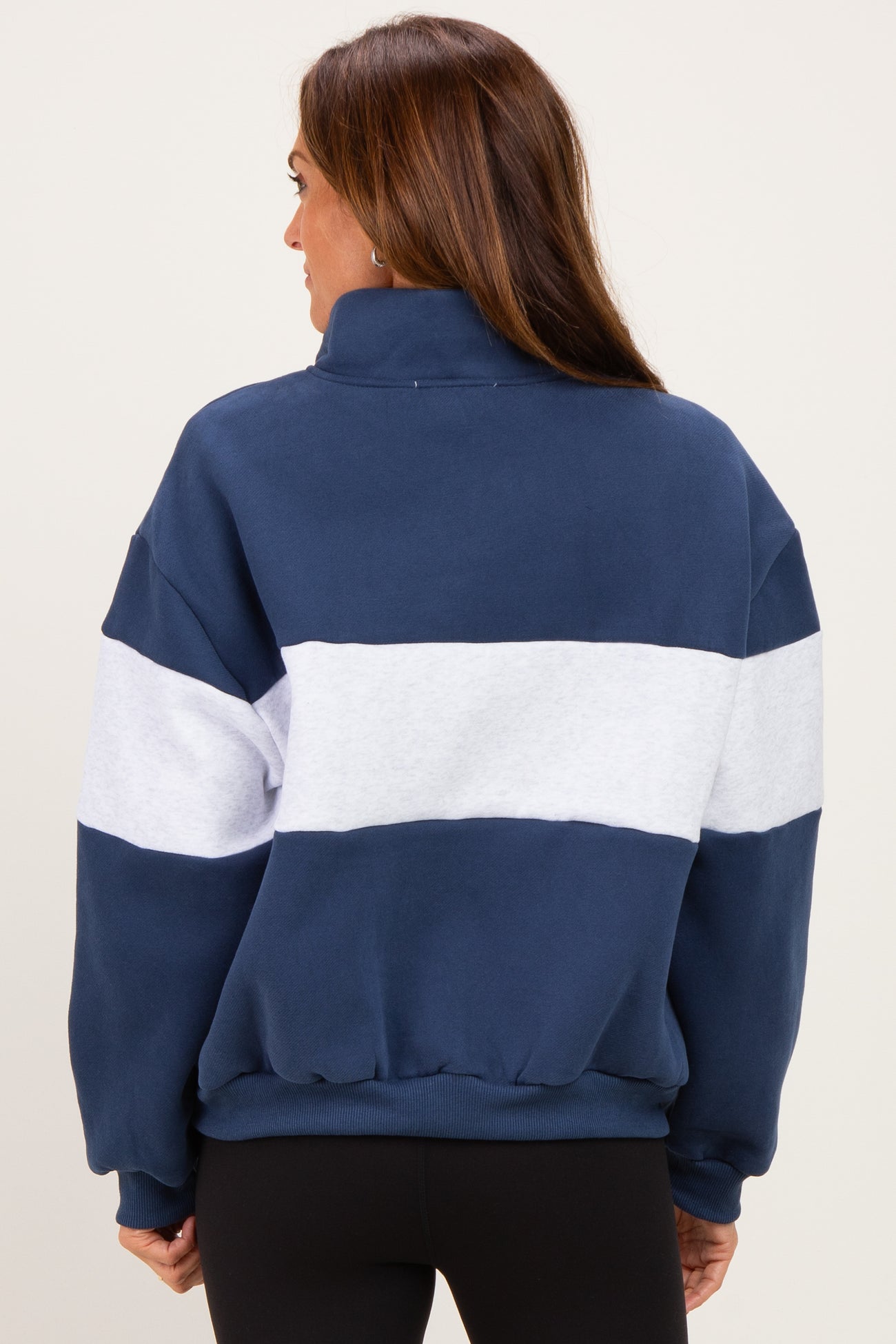 woman wearing a navy blue and white color-blocked sweatshirt with a high collar and relaxed fit