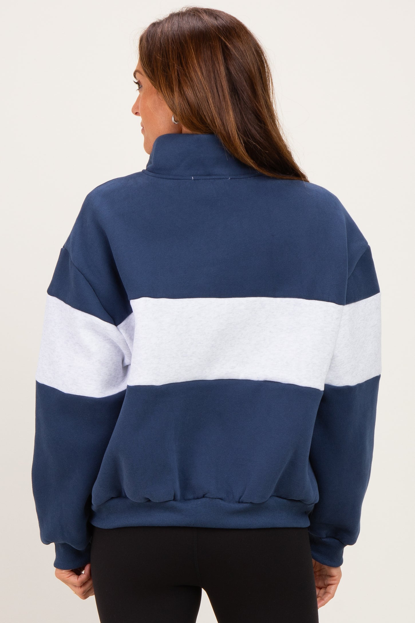 woman wearing a navy blue and white color-blocked sweatshirt with a high collar and relaxed fit