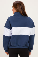 woman wearing a navy blue and white color-blocked sweatshirt with a high collar and relaxed fit
