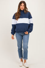 woman wearing a navy blue and light gray color block maternity hoodie and relaxed fit jeans