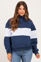 woman wearing a navy and light blue color-blocked maternity pullover sweatshirt with a quarter zip