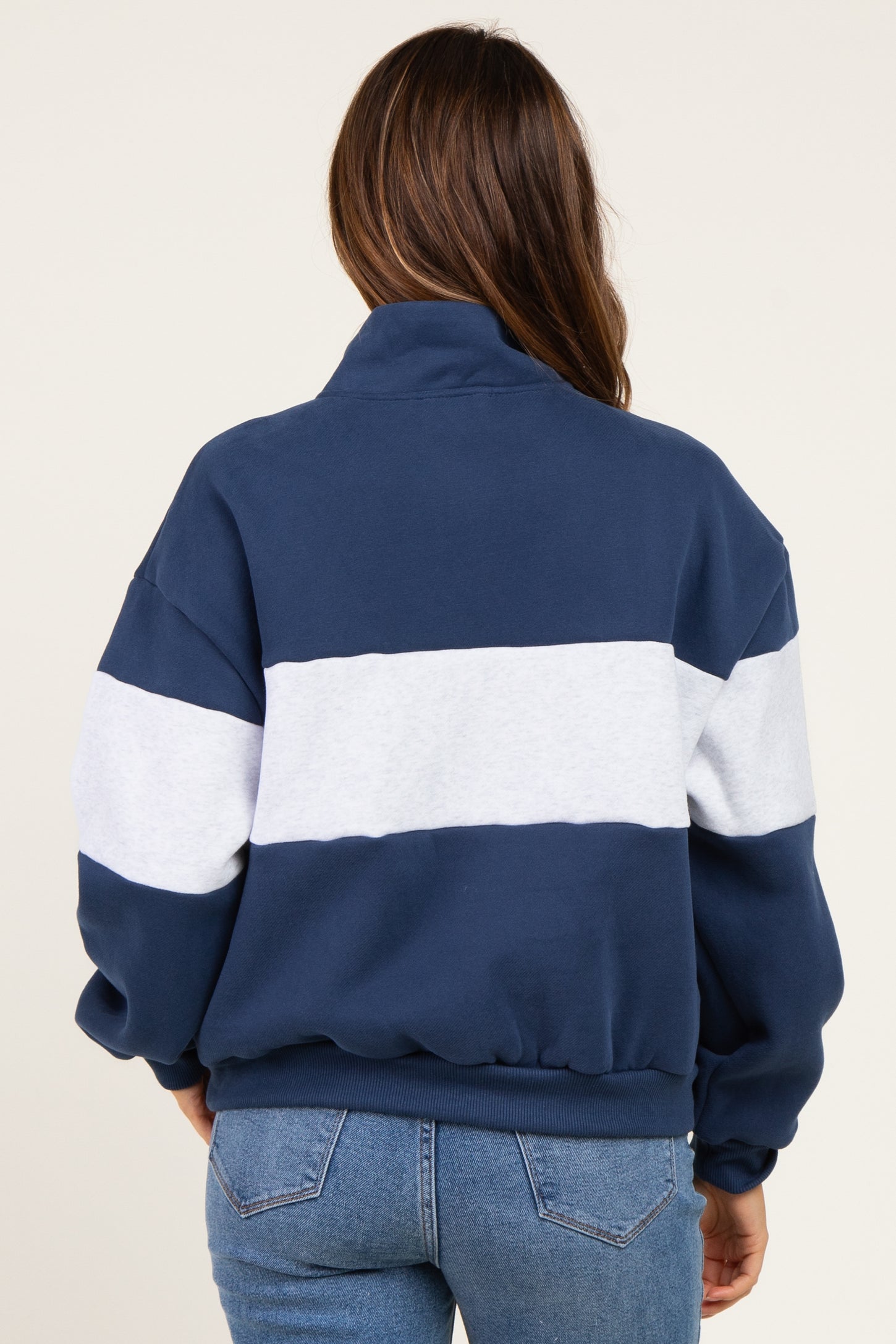 woman wearing a navy and gray striped maternity sweatshirt, showing a relaxed fit from the back