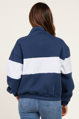 woman wearing a navy and gray striped maternity sweatshirt, showing a relaxed fit from the back