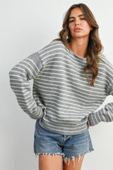 woman wearing a gray striped oversized sweater with a ribbed hem and distressed denim shorts