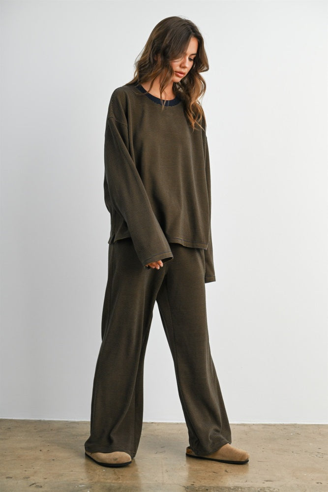 woman wearing an oversized dark olive green loungewear set with a relaxed fit and round neckline