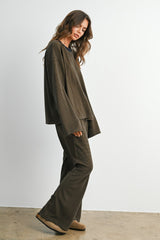 woman wearing a loose-fitting olive green long sleeve top and matching wide-leg pants in a cozy loungewear style