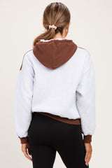 woman wearing a grey and brown color-block maternity hoodie with a relaxed fit and a hood
