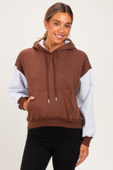 woman wearing a brown and gray color block maternity hoodie with a front pocket and relaxed fit