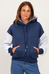 woman wearing a navy and gray color block hoodie with a front pocket and drawstring hood