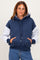 woman wearing a navy and gray color block hoodie with a front pocket and drawstring hood