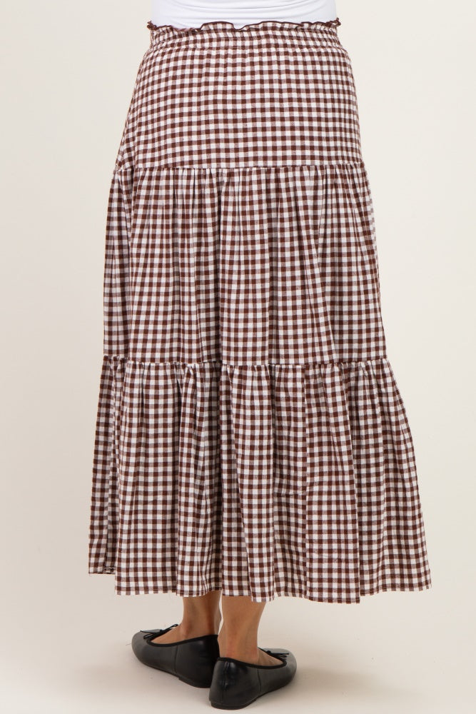 woman wearing a brown and white gingham maternity maxi skirt with tiered ruffles