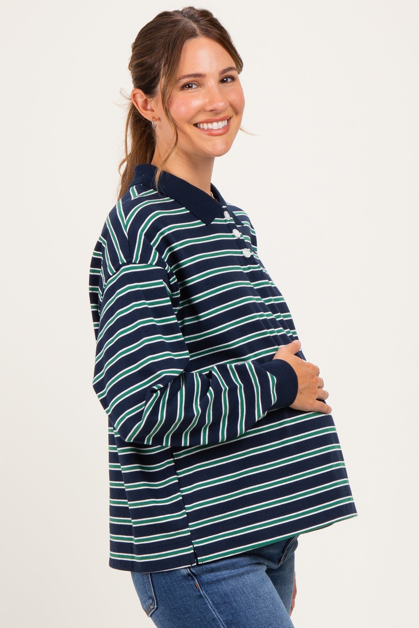 woman wearing a navy blue and white striped maternity sweatshirt with a baby bump visible