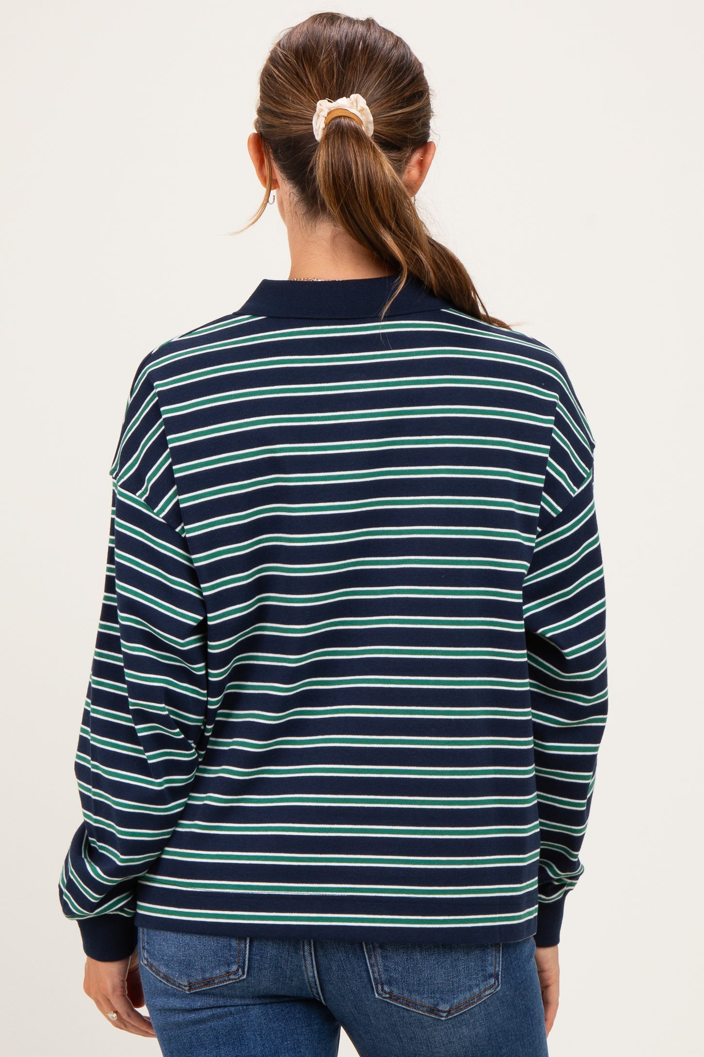 woman wearing a navy blue and green striped maternity sweatshirt, seen from the back