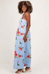woman wearing a light blue floral maternity maxi dress, showcasing her baby bump