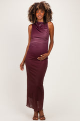 woman wearing a burgundy sleeveless maternity gown with a draped neckline and a visible baby bump