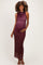 woman wearing a burgundy sleeveless maternity gown with a draped neckline and a visible baby bump