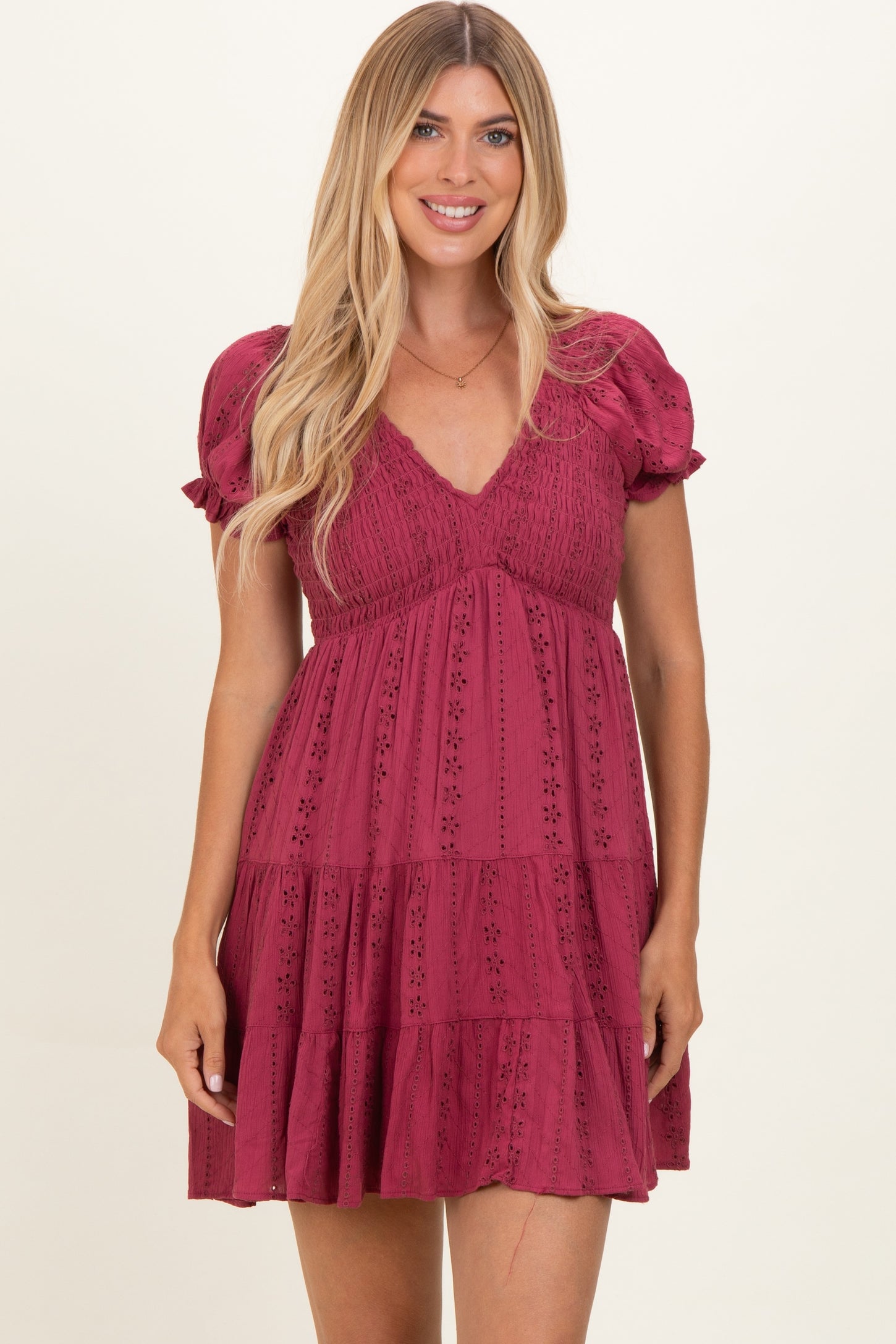 woman wearing a burgundy short puff sleeve dress with a v-neck and tiered skirt