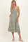 woman wearing a green strapless midi dress with a floral print and pockets