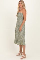 woman wearing a green strapless floral midi dress with a fitted bodice and flared hem, standing sideways