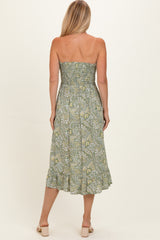 woman wearing a green floral strapless midi dress with a smocked bodice and ruffled hemline, viewed from the back
