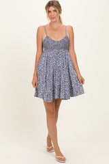 woman wearing a navy blue floral sundress with thin straps and a flared skirt