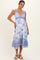 woman wearing a blue and white floral print maternity dress with tie straps and a visible baby bump