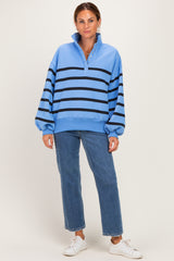 woman wearing a light blue striped sweatshirt with a collar and button detail, paired with blue jeans