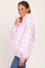 woman wearing a pink striped oversized sweatshirt with a high collar and button details