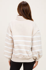 woman wearing a beige striped pullover sweatshirt with balloon sleeves and a high collar, view from the back