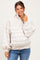 woman wearing a beige striped maternity sweatshirt with a collared neckline and button details, smiling at the camera
