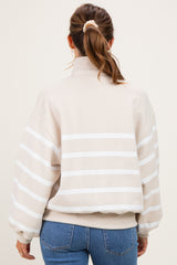 woman wearing a beige striped maternity sweatshirt with a high neck and balloon sleeves, seen from the back