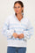 woman wearing a light gray and blue striped pullover sweatshirt with a collar and button details