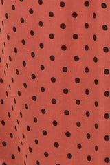 maternity wear in a rust-colored fabric with black polka dots