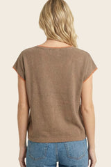 woman wearing a brown short sleeve top with orange trim, viewed from the back