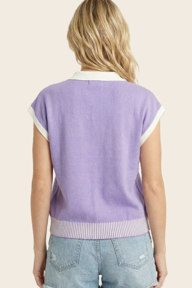 woman wearing a lavender short sleeve sweater with white collar and striped hem, seen from the back