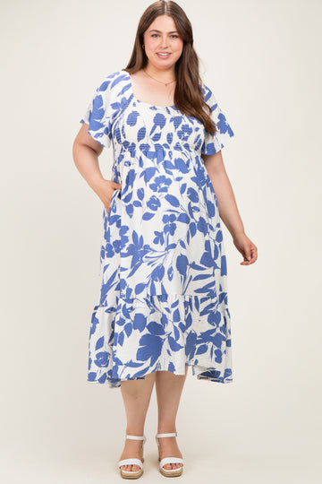 woman wearing a white and blue floral print maternity dress with short sleeves and pockets in a flowing style