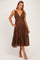 woman wearing a brown polka dot maternity dress with a v-neck and tiered skirt, showing off her baby bump