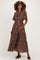 woman wearing a brown floral maternity maxi dress with short sleeves and a gathered waist, holding her baby bump