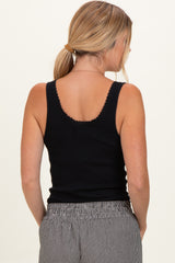 woman wearing a black ribbed tank top with scalloped neckline and casual striped pants