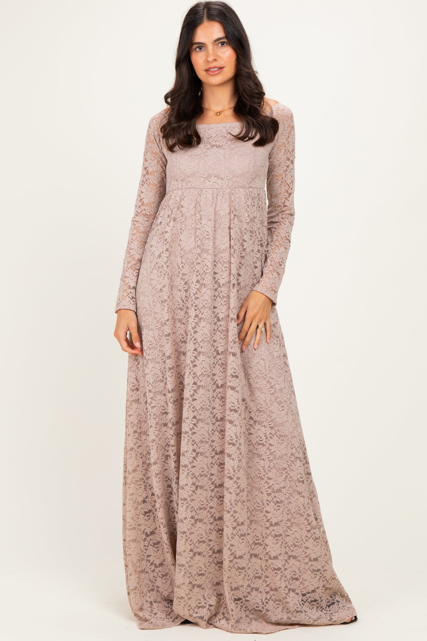 woman wearing a long sleeve beige lace maxi dress with a fitted bodice and flowing skirt