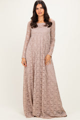 woman wearing a long sleeve beige lace maxi dress with a fitted bodice and flowing skirt