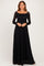 woman wearing a long sleeve black lace maxi dress with a square neckline and fitted waist