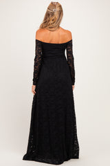 woman wearing a black off-the-shoulder lace maternity dress with long sleeves, showing a flowing maxi length and back view