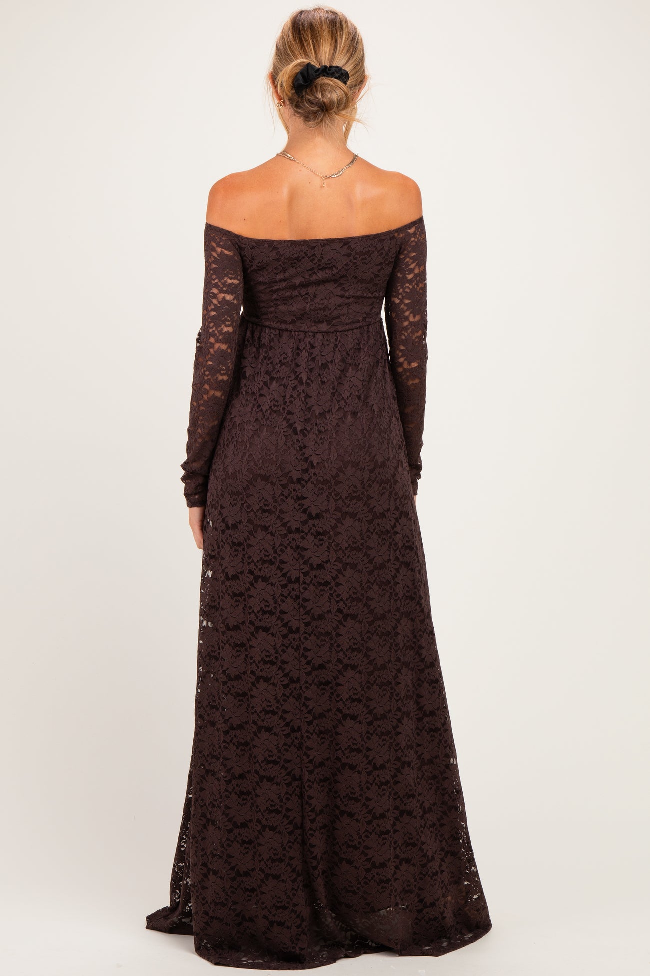 woman wearing a long sleeve off-the-shoulder dark brown lace maternity dress, showing the back design