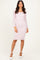 woman wearing a light pink long sleeve lace bodycon dress with a square neckline and white heels